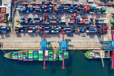 aerial view of shipping containers and barges at a port