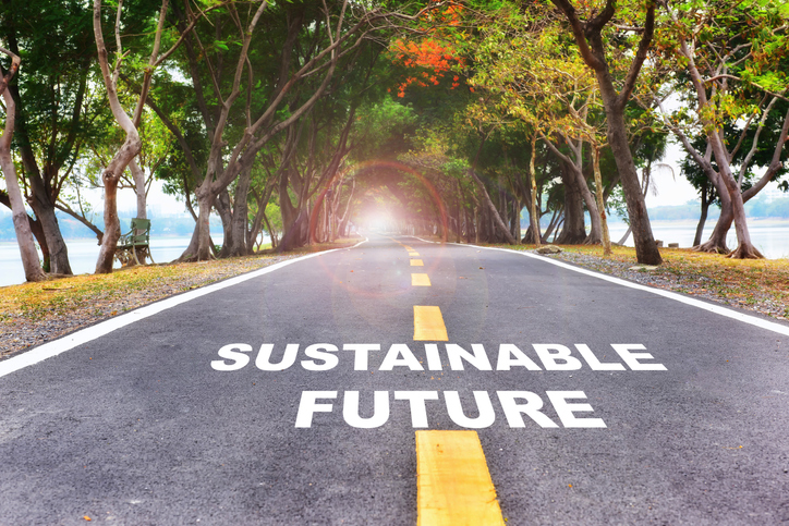 Road leading into trees with words "sustainable future"
