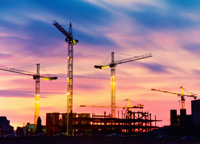 commercial construction site cranes with sunset background