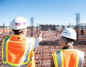 Female and male superintendents overseeing commercial construction project