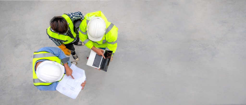 Professionals at a commercial construction site reviewing inventory and supply chain delays